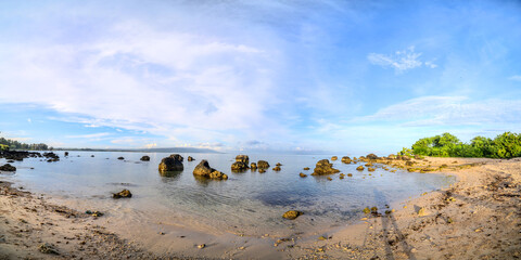 Peaceful Coastal Morning Panorama. Calm Waters and Rocky Beach Landscape. Idyllic Coastal Panorama with Rocks