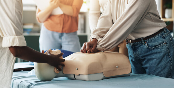 First aid, training and hands of people with dummy for CPR, chest compression lesson or life saving procedure. Business, teamwork or healthcare class for employee rescue, workplace safety or learning