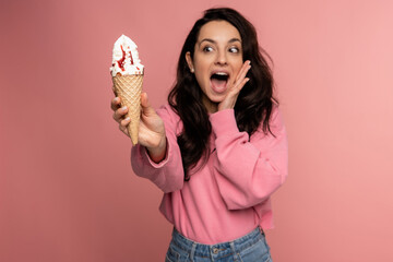 Hungry young female feeling afraid of eating her favorite high-carb dessert during the studio photo...