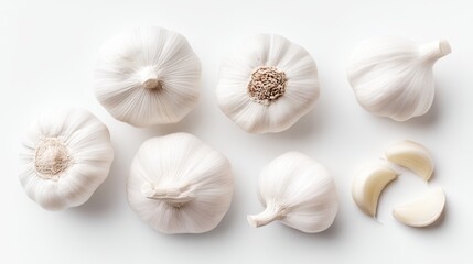 Fototapeta premium Fresh Garlic Bulbs and Cloves Displayed on White Background for Culinary Use and Decoration