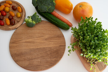 Bright culinary ingredients, vegetables and microgreens are laid out on the table near the wooden cutting board. Healthy Eating