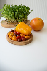 Bright culinary ingredients, vegetables and microgreens are laid out on the table near the wooden cutting board. Healthy Eating