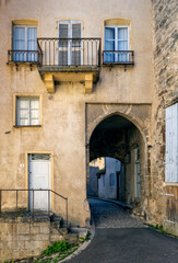 Old building facade featuring wooden door, iron balcony, and geometric stone wall pattern.For the background of your photos and collages.