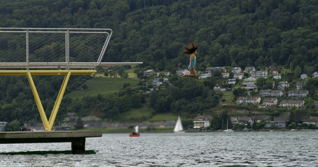 Child diving into the lake from a platform in slow-motion at 800 fps, capturing the thrill and...