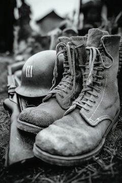 &Eacute;quipement militaire vintage au sol avec casques, bottes et fusils, sc&egrave;ne de m&eacute;moire illustrant la guerre, le sacrifice et les traces laiss&eacute;es par les soldats sur le terrain