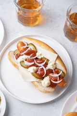 Pickled cucumbers fresh onion frankfurter sausage hot dog sandwich on a white background