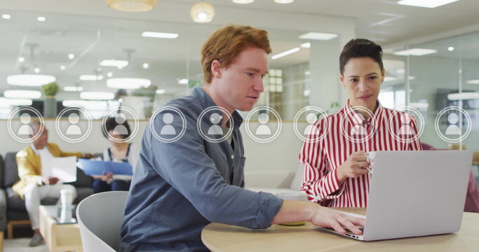 Image of user icons over caucasian colleagues talking in office