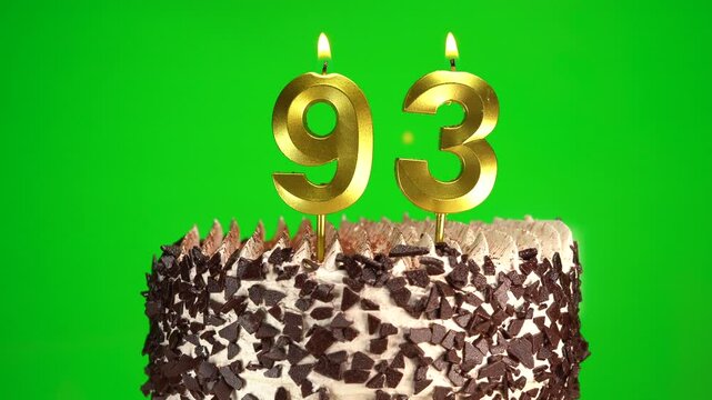 Burning candles number 93 on birthday cake against chroma key background. Ninety-third birthday. Birthday and anniversary celebration