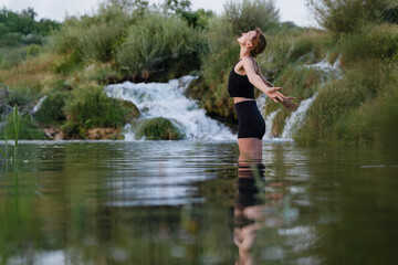 Fototapeta premium Young woman practicing yoga on nature. Holistic Health & Mental Well-Being.