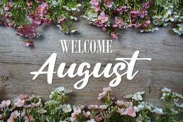 Welcome August text with flowers frame on wooden background