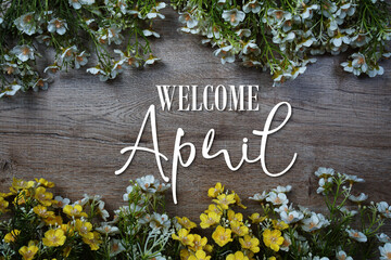 Welcome April text with flowers frame on wooden background. © may1985