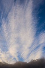 Cirrus clouds over dark clouds in blue sky