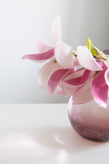 magnolia wreath in glass vase on wall background