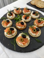 Smoked salmon canap&eacute;s with cream cheese and olives