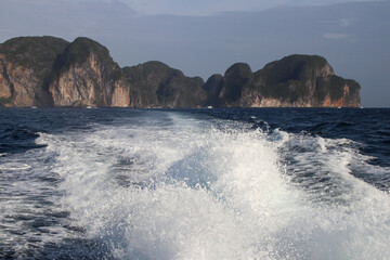 Waves made by a boat leaving Phi Phi Island with island in the background