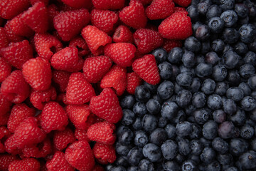 Blueberries and raspberries as a background. Top view.