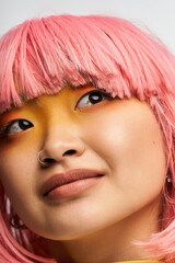 Fototapeta premium Vibrant young woman with pink hair and bold makeup exuding confidence and style