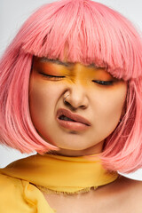 Fototapeta premium Expressive moment featuring a young beautiful Asian woman with colorful hair and makeup