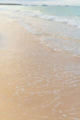 Soft golden sand meets gentle waves at a serene beach during sunset moment