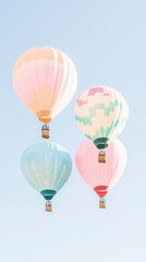 Fototapeta premium Pastel Hot Air Balloons Ascending in a Clear Blue Sky