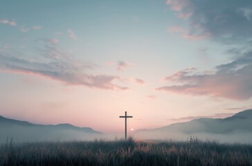 Obraz premium A serene landscape featuring a cross silhouetted against a pastel sky, with misty mountains and tall grass, evoking a sense of peace and spirituality.