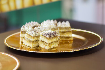 Delicious cakes on a golden plate