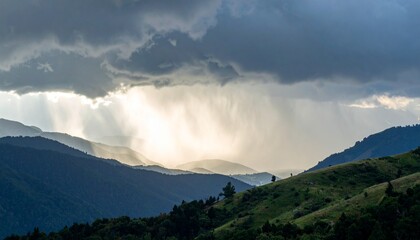 Rain falling over a mountain ridge under thick storm clouds as sunlight breaks through in the distance
