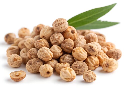 A close-up photograph of a pile of tiger nuts (chufa) on a white background, with a green leaf visible.