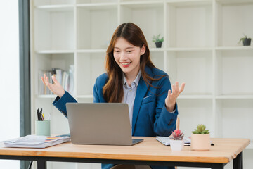 Excited Asian Businesswoman Working on Laptop
