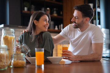 Young couple enjoying breakfast together in the kitchen

