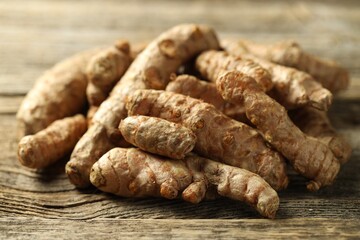 Pile of tumeric rhizomes on wooden table, closeup