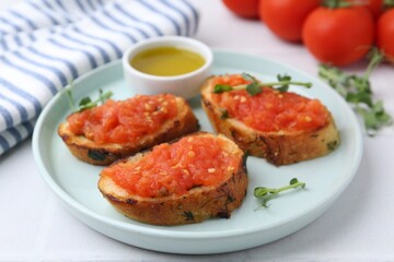 Tasty bread with tomatoes, microgreens and oil on white table, closeup