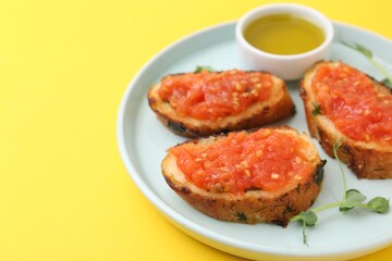 Tasty bread with tomato, microgreens and oil on yellow background, closeup. Space for text