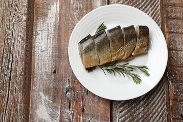 Smoked herring and rosemary on wooden table, top view. Space for text