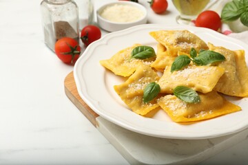 Delicious ravioli with cheese and basil served on white marble table, closeup. Space for text