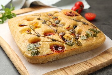 Delicious focaccia with flowers made of vegetables on grey table, closeup