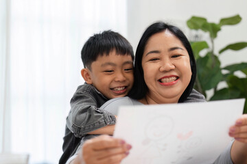 Creative Moments and Family Love. A mother and her son share a loving embrace while admiring his artwork.