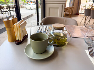 Hot green tea served at a cozy urban cafe table. Moment of pause, flavor and quiet enjoyment in the city