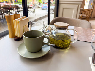 Minimalist cafe tea setting with a focus on herbal tea. Slow living, clarity and simplicity during a midday break.