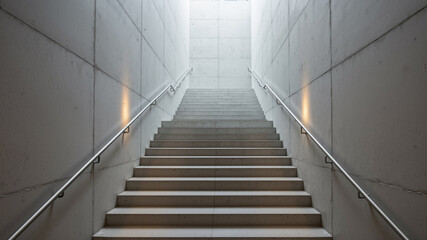 Obraz premium The image shows a stairway in a building with concrete walls and metal railings