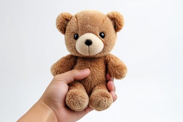 Fototapeta premium Hand holding a cute brown stuffed bear with button eyes, perfect gift idea for any occasion or celebration
