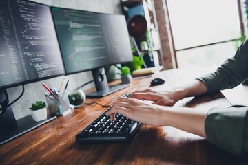 Young programmer working remotely with dual monitors coding on a modern workspace desk highlighting tech and freelance creativity