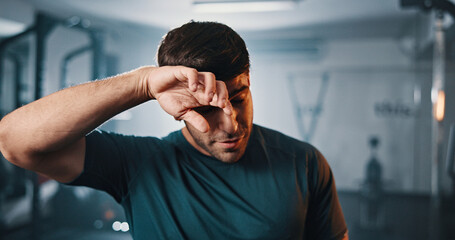 Fototapeta premium Tired, active and man with sweat at gym for fitness, intense exercise and recovery for workout. Male person, fatigue and burnout with physical training, endurance challenge and bodybuilding at centre