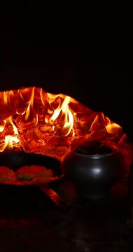 Authentic cooking process inside a live-fire oven. A warm, inviting scene of homemade food slowly roasting in a traditional setting.