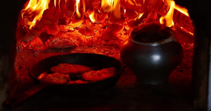 Traditional Belarusian and Slavic dishes cooking in a rustic oven. Hearty meals like draniki (potato pancakes) and porridge slowly baking in real fire. Authentic countryside kitchen