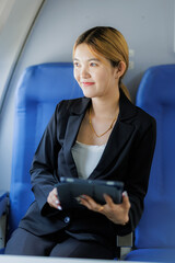 While flying to her next destination, an Asian businesswoman concentrates on refining her...