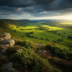 Obraz premium Sunlit Valley Under Dramatic Skies: A stunning panorama reveals a verdant valley bathed in golden light, nestled beneath a dramatic sky teeming with storm clouds.
