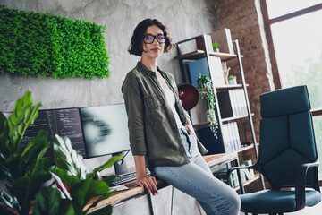 Young woman programmer in a stylish office working on coding projects, focusing on software...