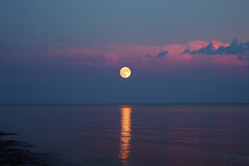 Stunning full moon over ocean at sunset art piece  
