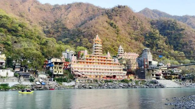 Tera manzil temple and colorful rafting boat on Ganga river in Rishikesh India